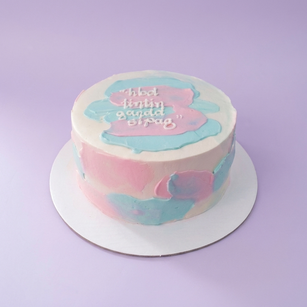 Minimalist bento cake with white icing and abstract pink and light blue palette knife strokes featuring a birthday message.