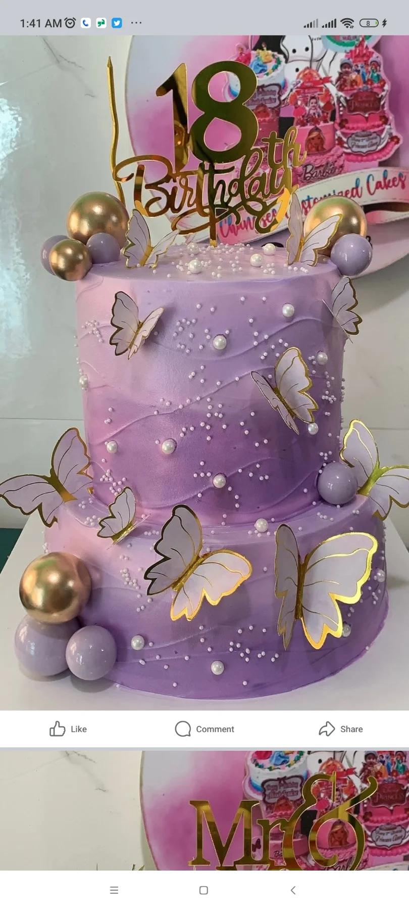 Two-tier lavender and purple gradient cake decorated with white and gold butterflies, gold spheres, and white pearls.